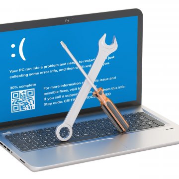 registry cleaners laptop with error on screen wrench and screwdriver on keyboard